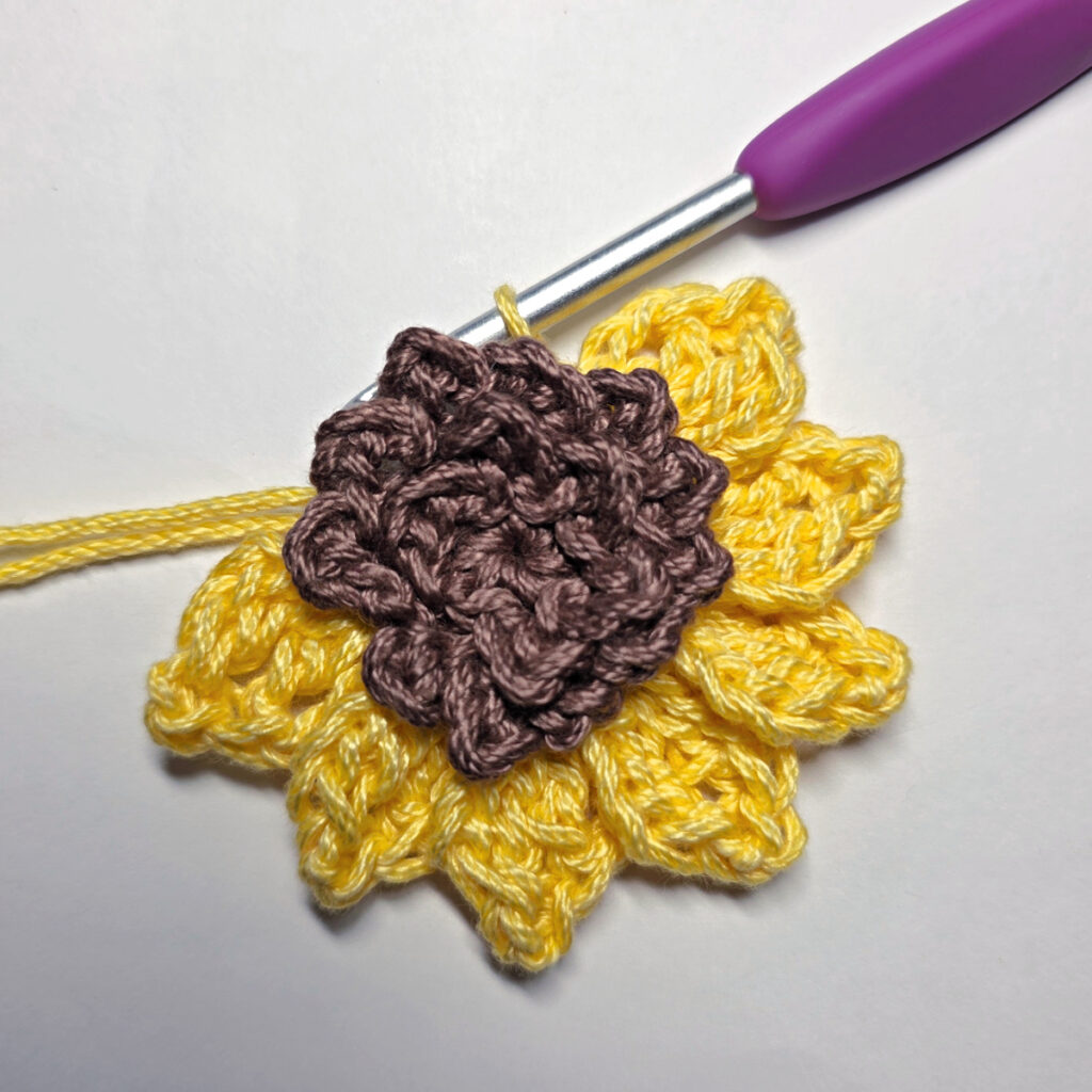 Making a crochet sunflower applique.