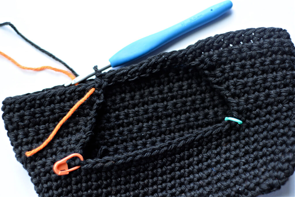 Crocheting a black monster bag.