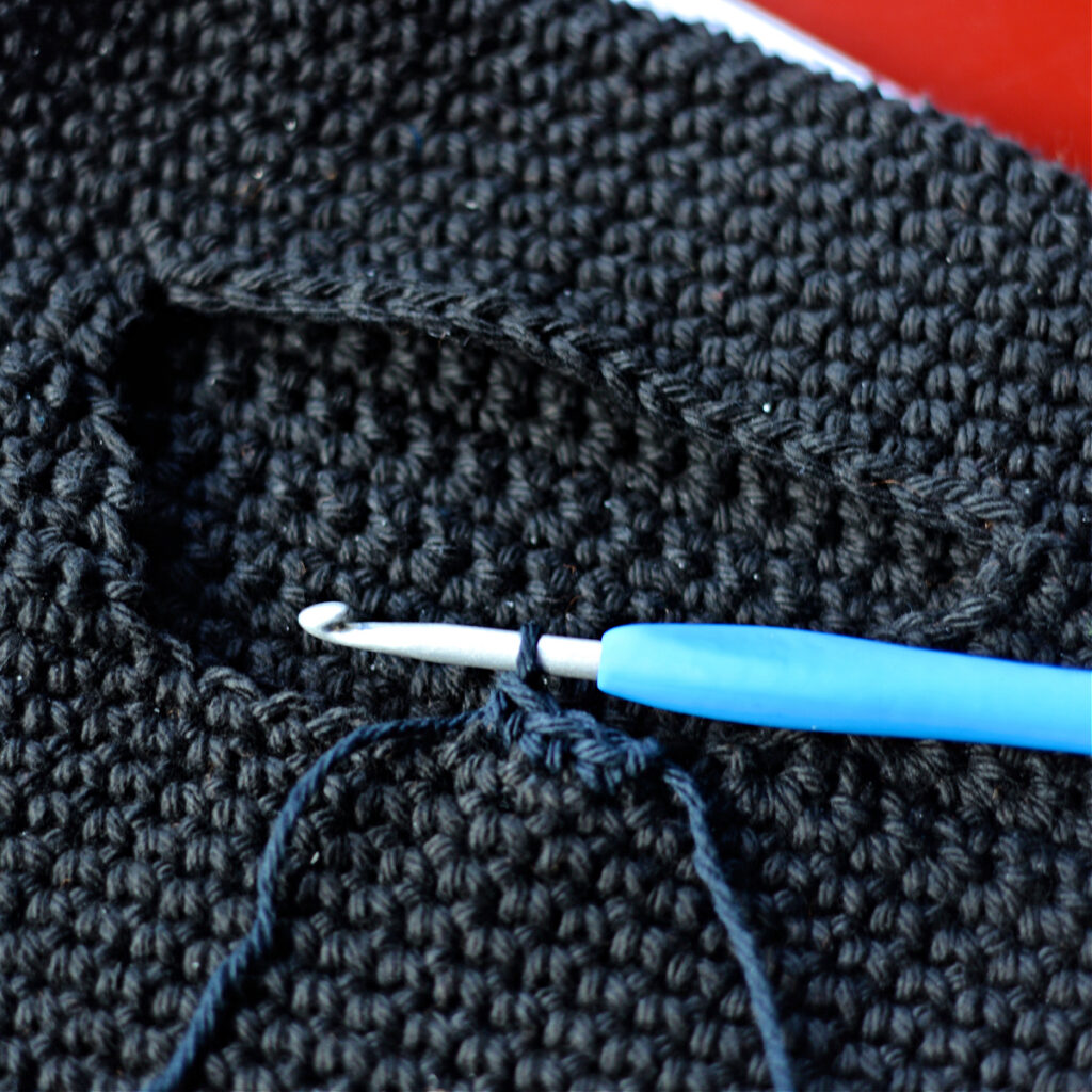 Edging the mouth of a black monster bag.