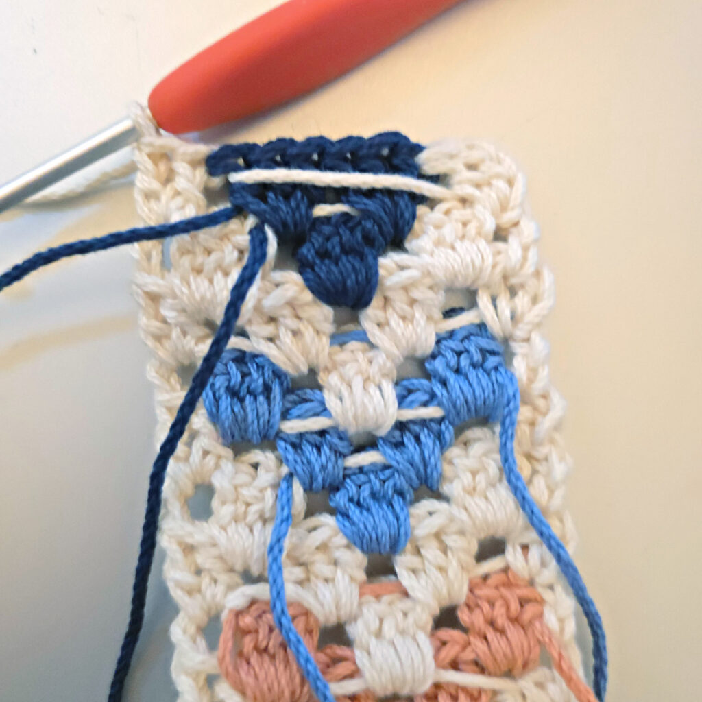 Making the colorful strap of a crossbody crochet bag.