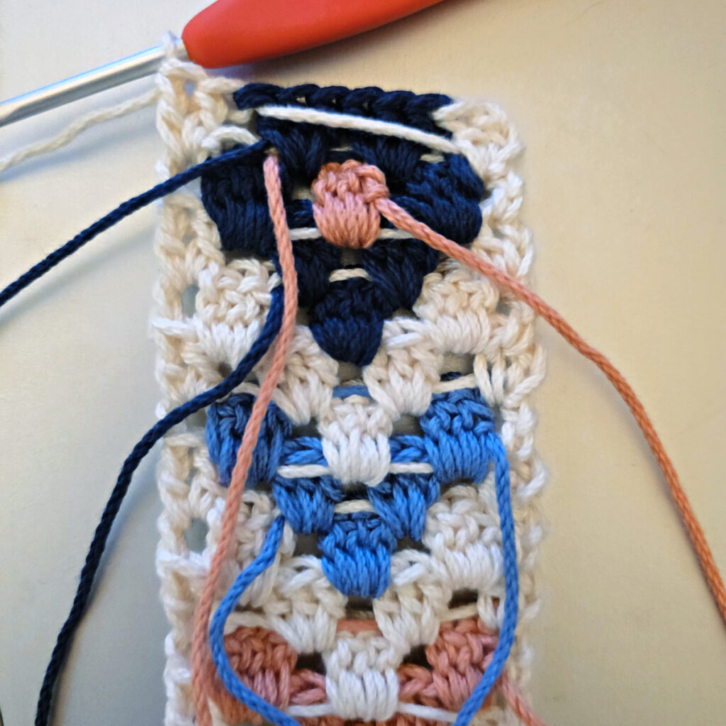 Making the colorful strap of a crossbody crochet bag.