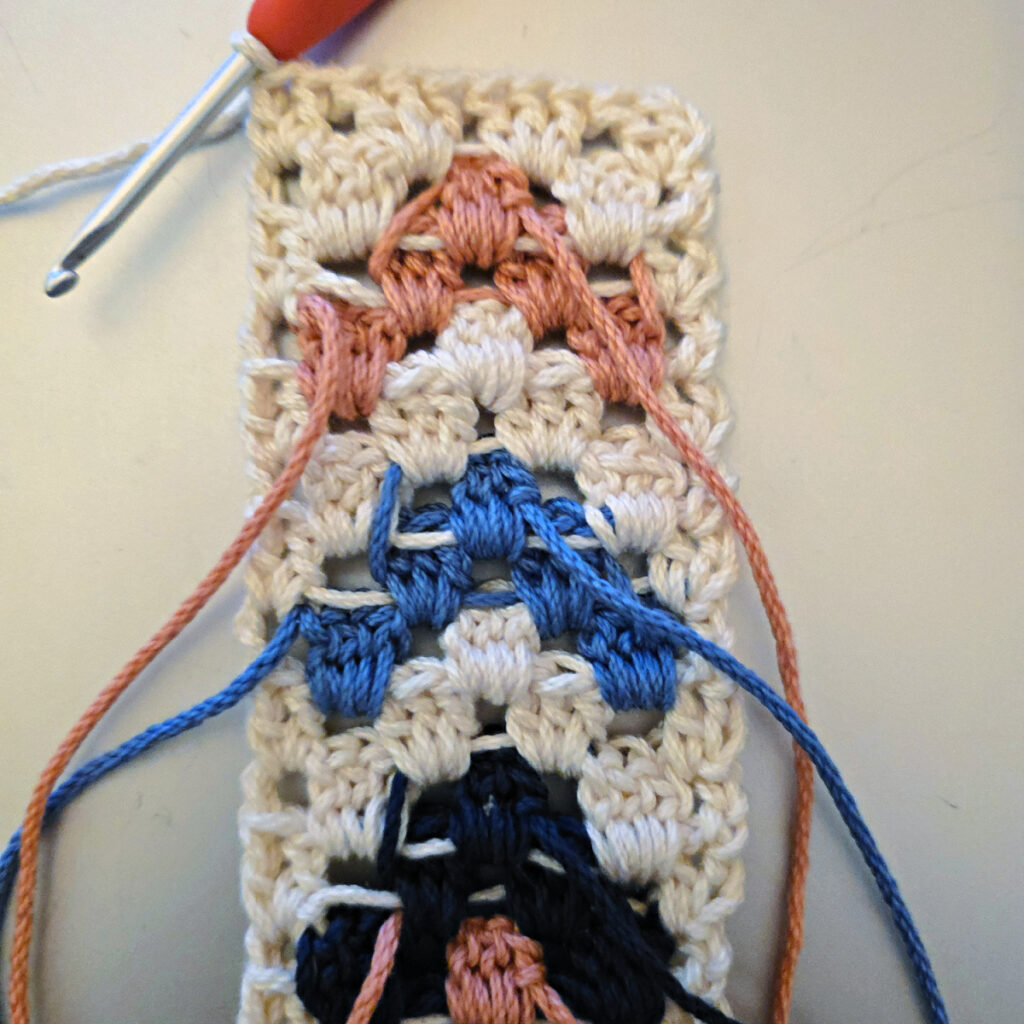 Making the colorful strap of a crossbody crochet bag.