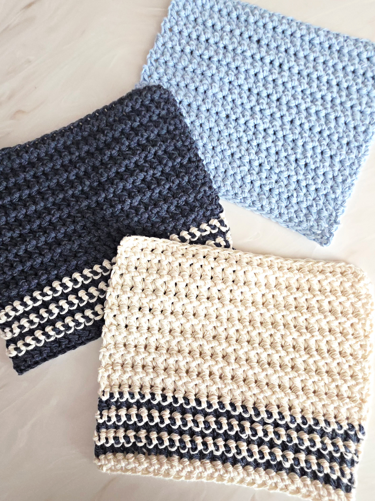 Blue and white crochet dishcloth against a marble background.