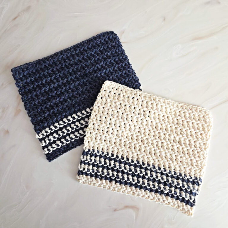Blue and white crochet dishcloth against a marble background.