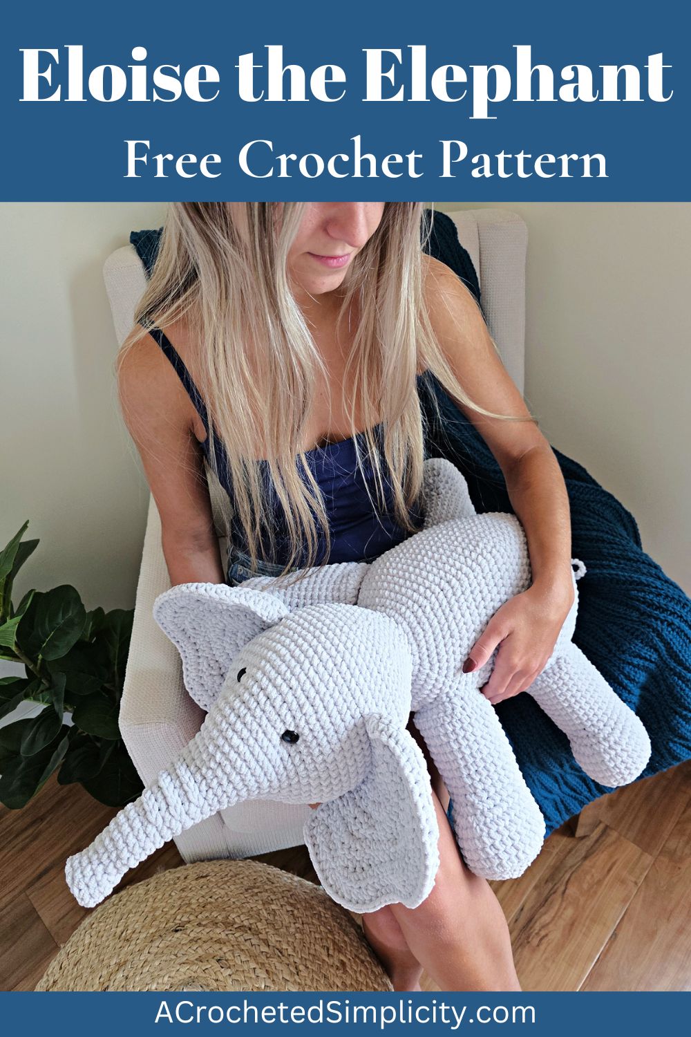A girl holding a large gray crochet amigurumi elephant.
