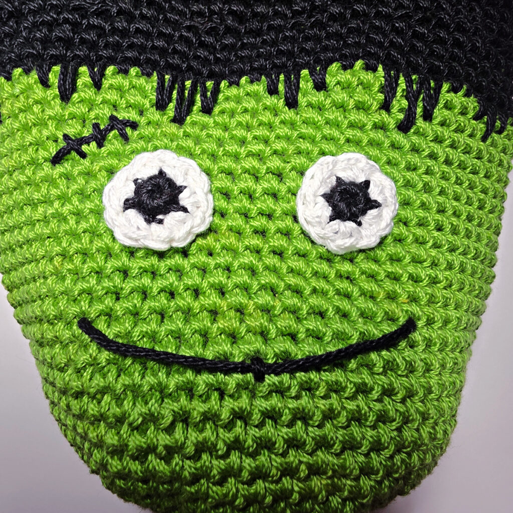 Crochet frankenstein's monster in green and black yarn.