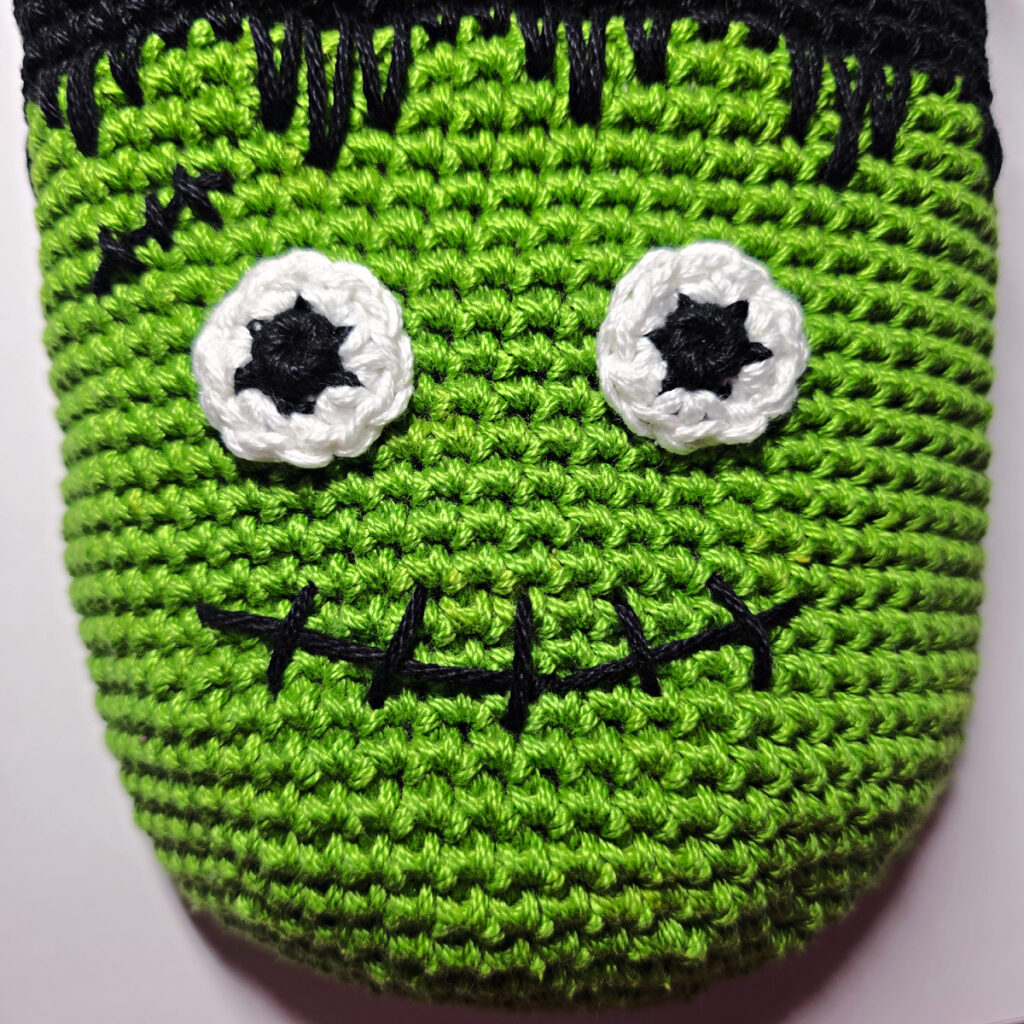 Crochet frankenstein's monster in green and black yarn.