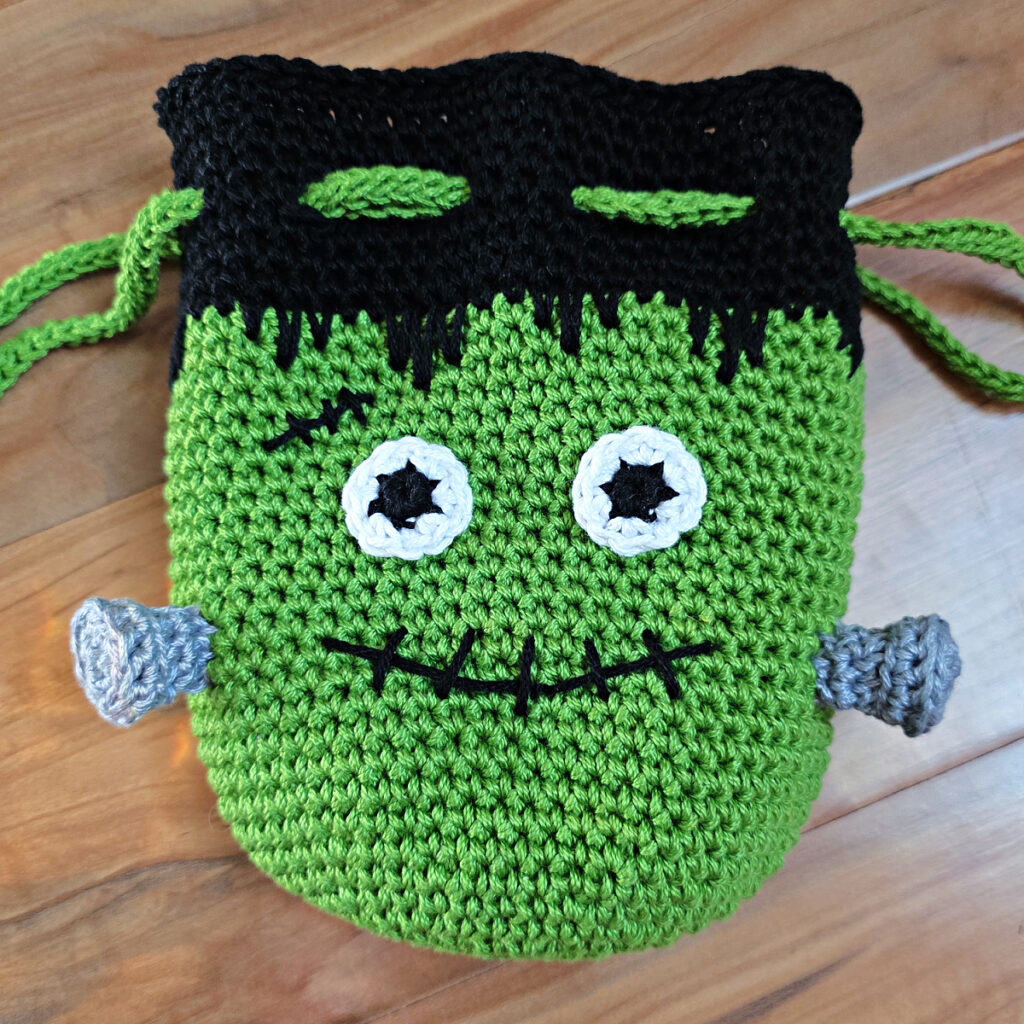 Crochet frankenstein's monster in green and black yarn.