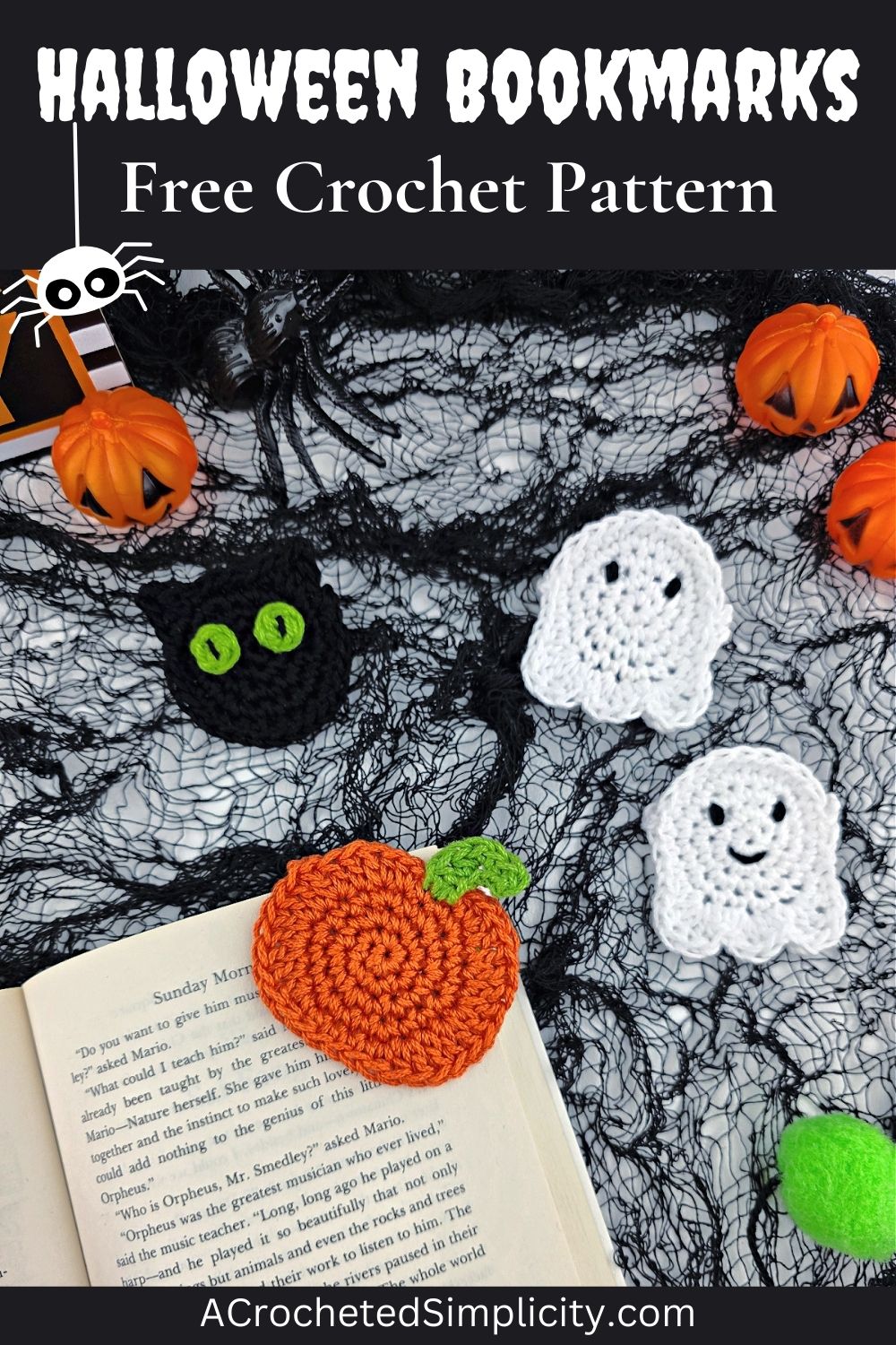 A crochet pumpkin bookmark attached to a book with a crochet ghost and cat in the background.