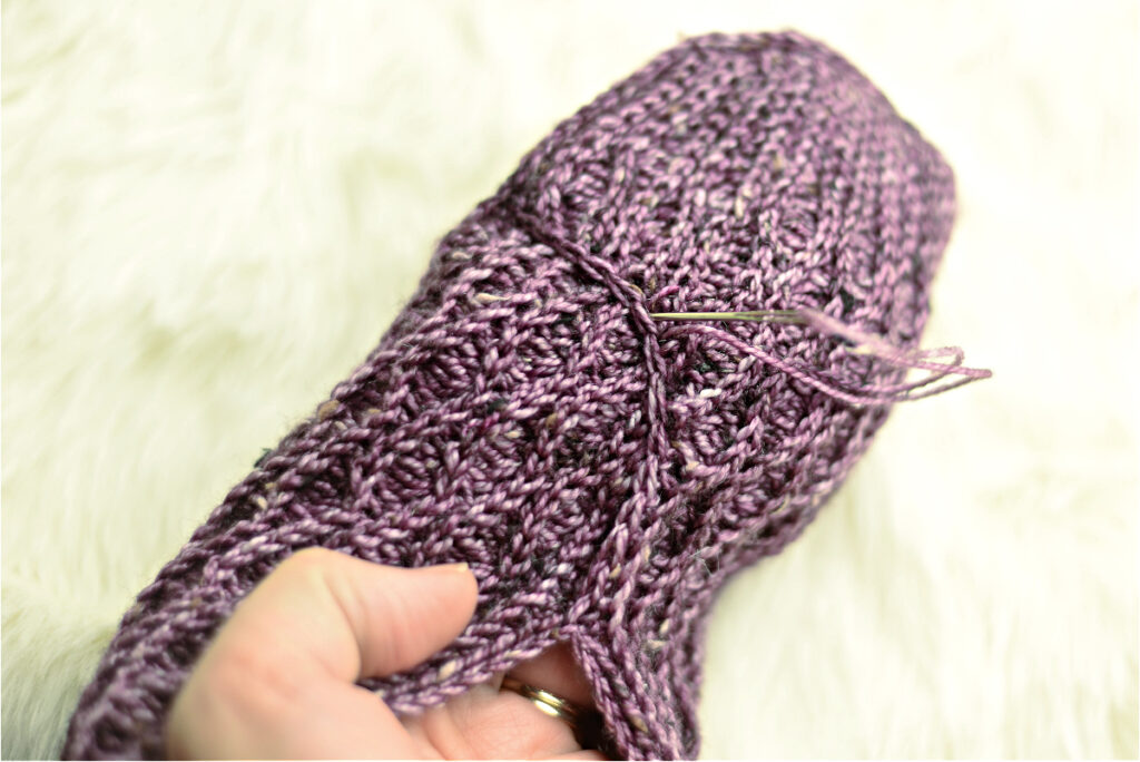 Stitching a purple crochet kimono slipper.