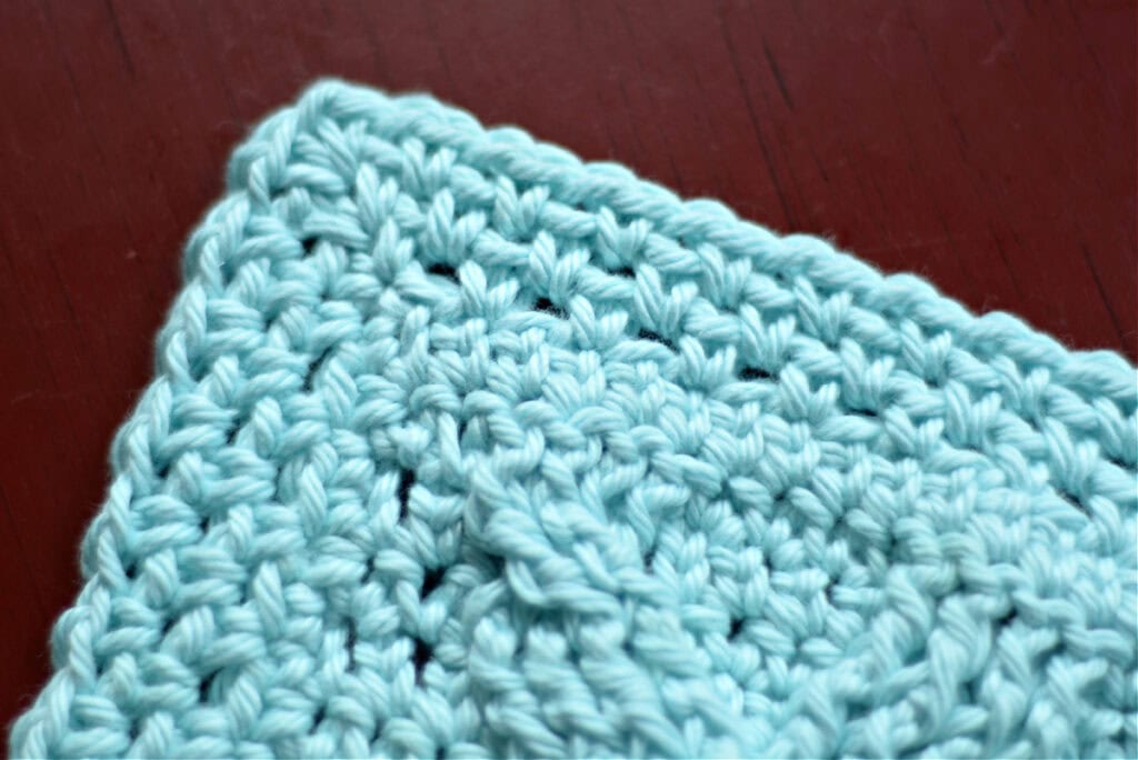 The border of a blue crochet blanket.