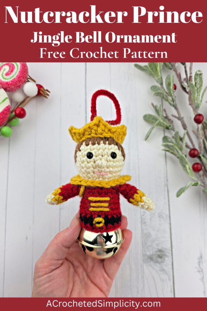 A crochet nutcracker prince ornament on a jingle bell.