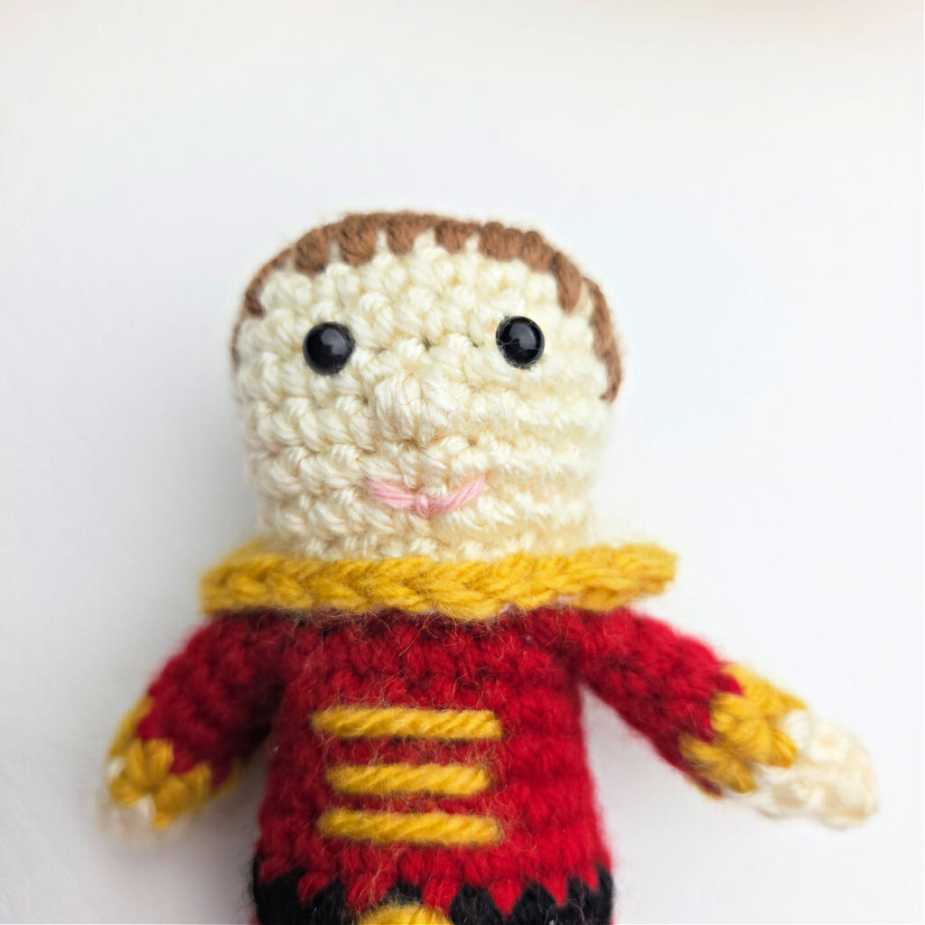 A nutcracker prince crocheted to make an ornament.