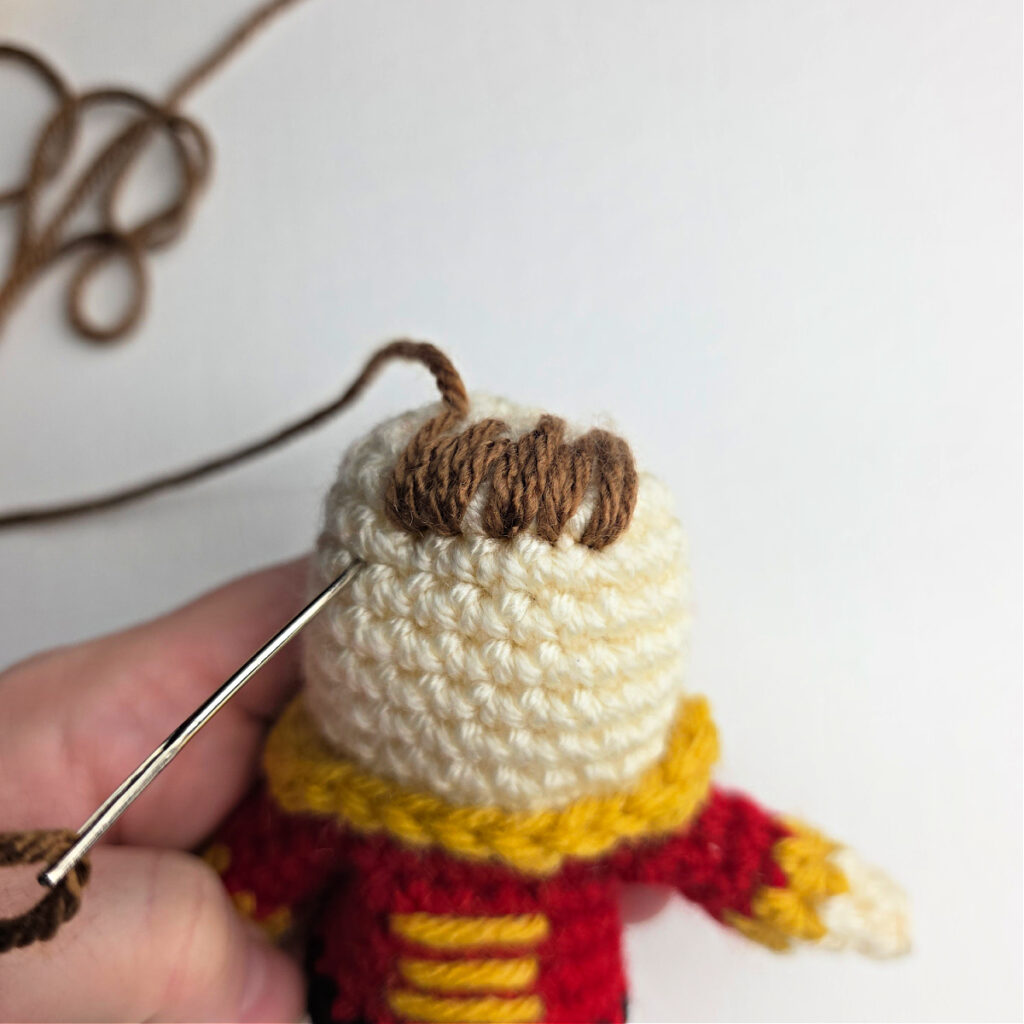 The first few strands of yarn used to create hair on the nutcracker prince ornament.