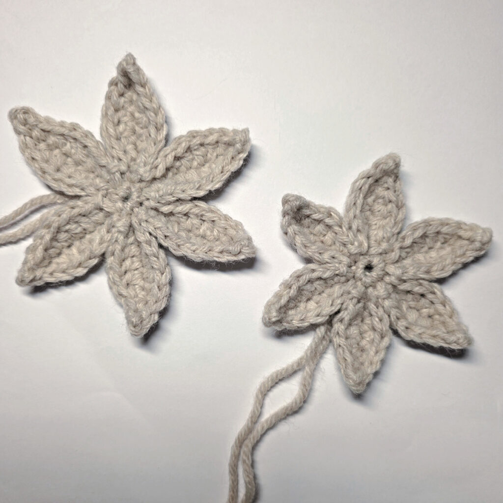 The top and bottom layers of a 3D crochet poinsettia made and ready to be joined.