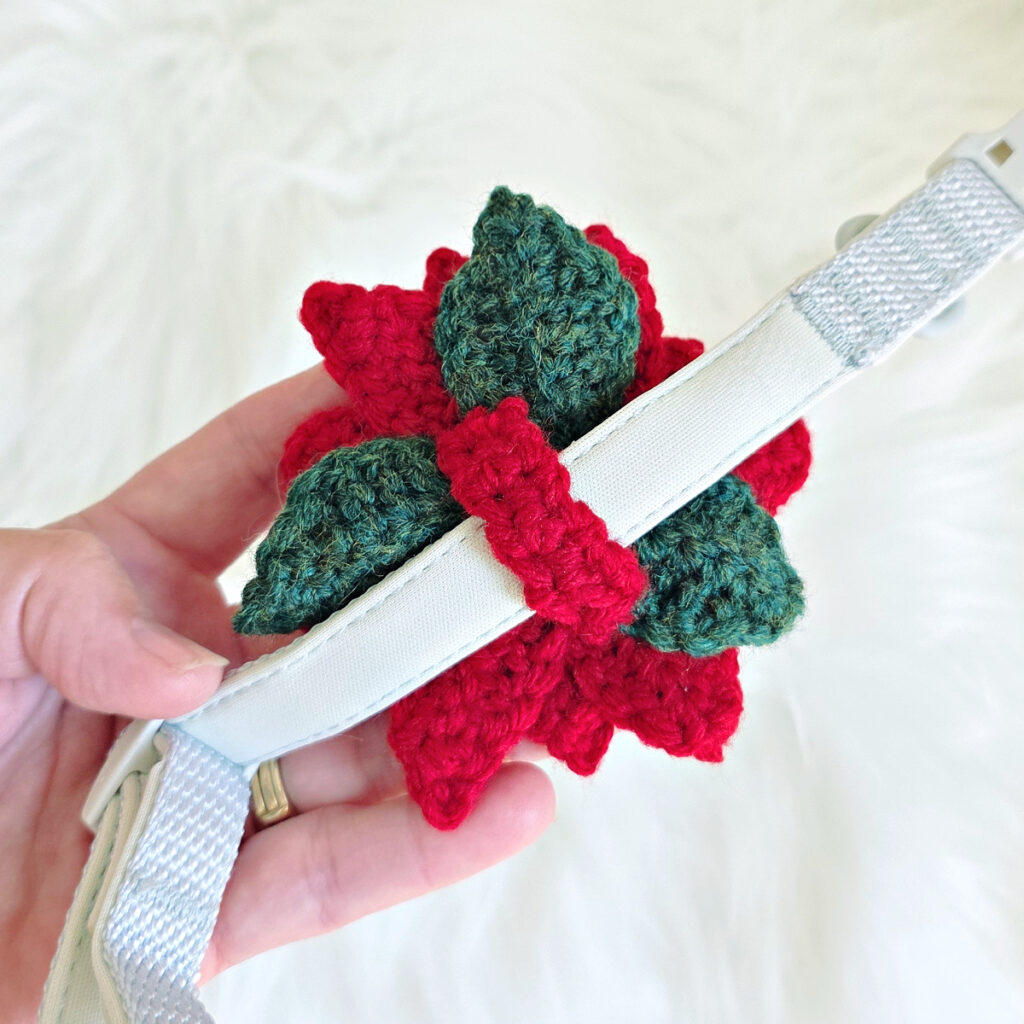 The backside of the poinsettia crochet dog collar flower to show the crochet strap that holds the flower on the dog collar.