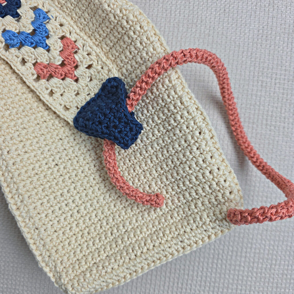 Attaching the button and strap to a crochet crossbody bag.