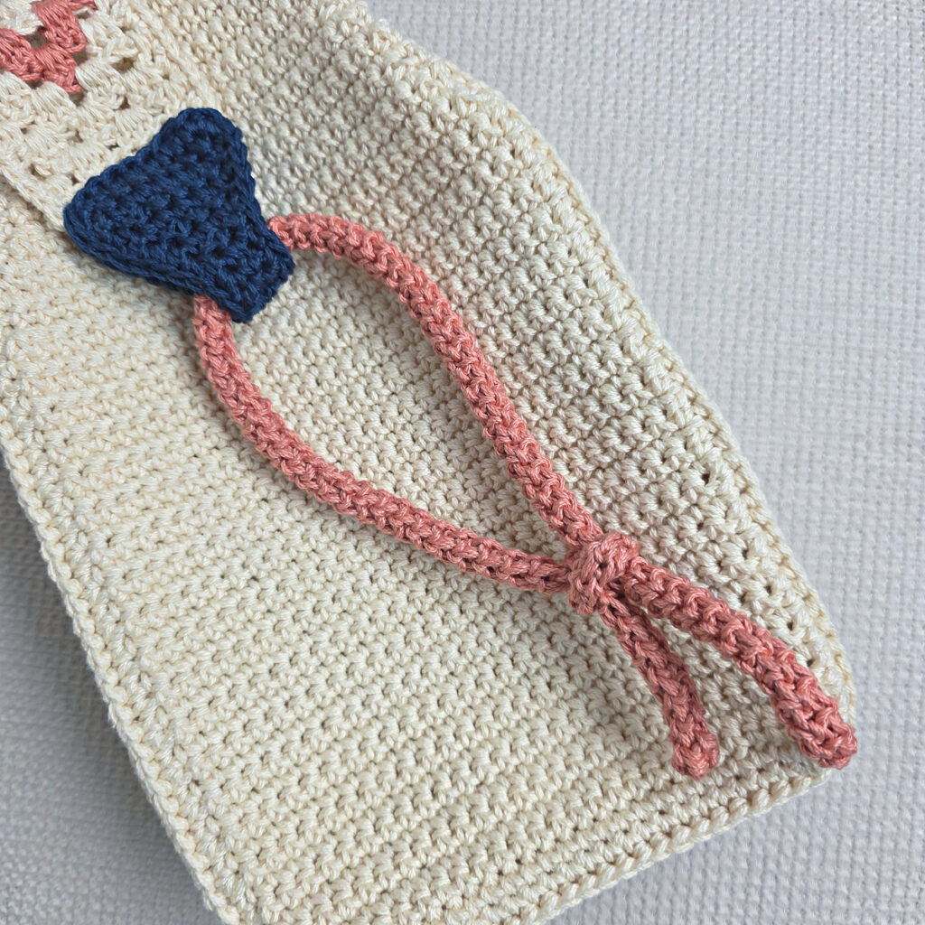 Attaching the button and strap to a crochet crossbody bag.