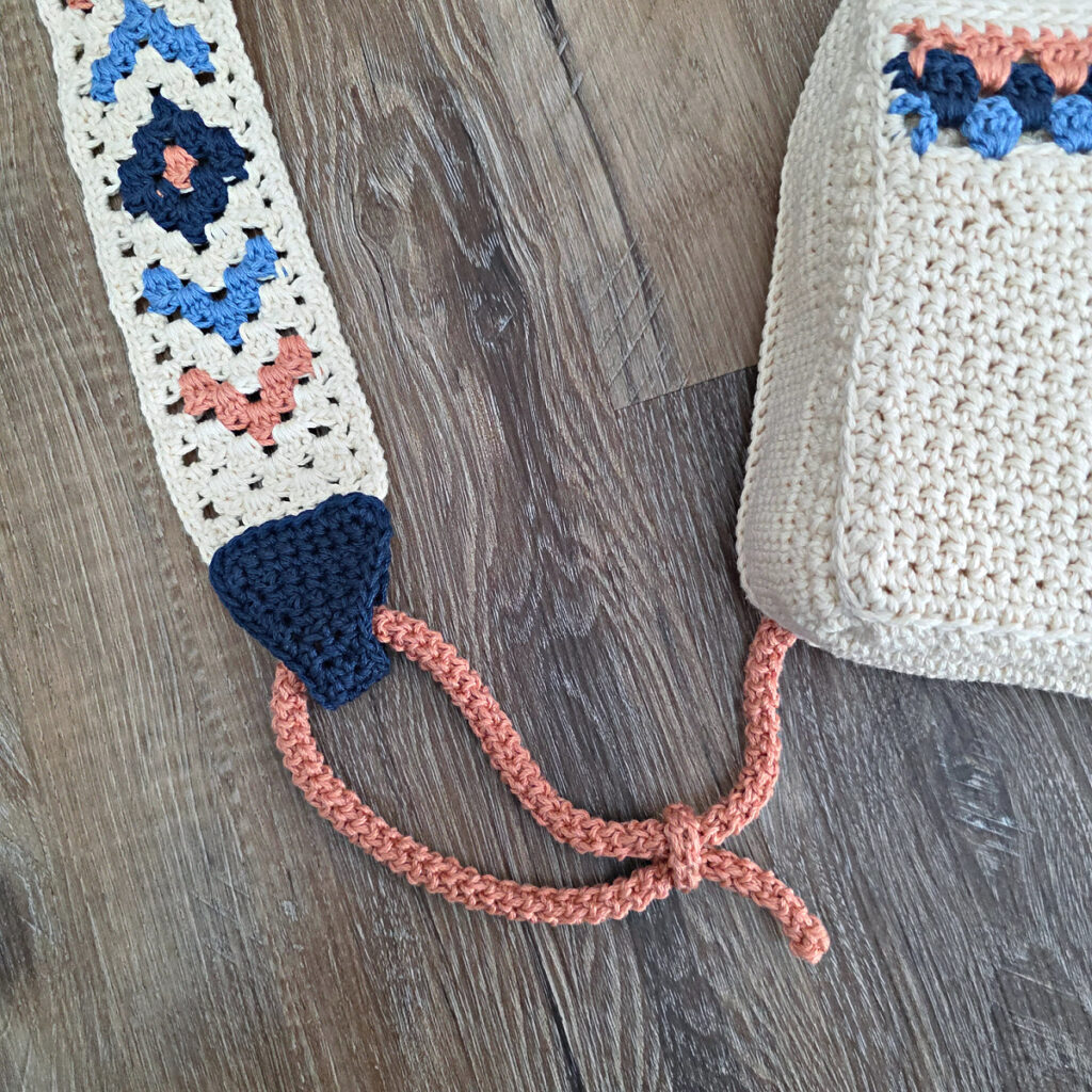 Attaching the button and strap to a crochet crossbody bag.