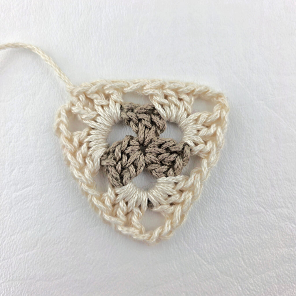 Round 2 of crochet granny stitch triangle.