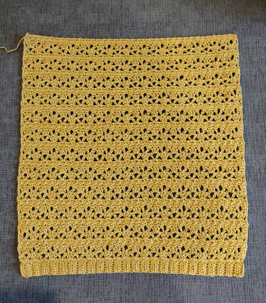 A piece of a yellow crochet tee.