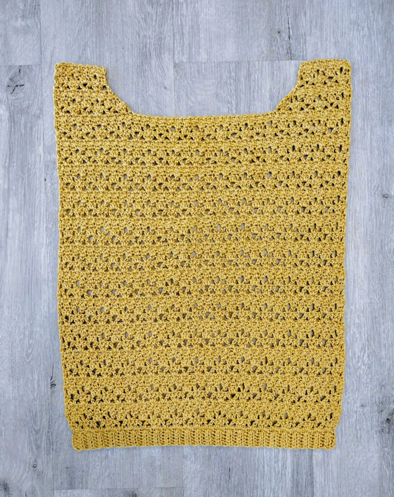 A piece of a yellow crochet tee.
